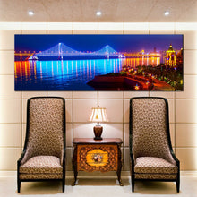 Load image into Gallery viewer, blue  city  beach  wall  art  night  lights  water  reflection  bay  cross  sea  bridge  panoramic  canvas  print In Living Room
