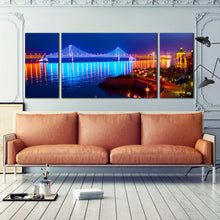 Load image into Gallery viewer, city  beach  canvas  print  blue  bay  cross  sea  bridge  scene  night  lights  water  reflection  3  piece  wall  art In Living Room
