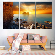Load image into Gallery viewer, Dramatic Sunset Canvas Wall Art Blue Sea Ocean Rocks Boulders Multi Canvas Yellow Sky Stony Beach  3 Piece Canvas Print In Living Room
