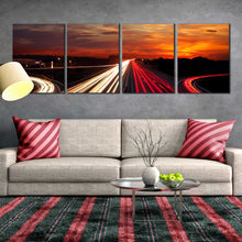 Load image into Gallery viewer, Moving car light trail through twilight city roads 4 piece canvas print In Living room
