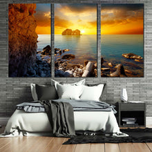 Load image into Gallery viewer, dramatic sunset canvas wall art blue sea ocean rocks boulders canvas set yellow sky stony beach 3 piece canvas print For Bedroom
