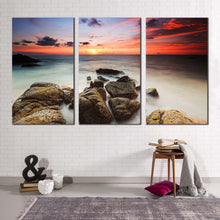 Load image into Gallery viewer, ocean boulders canvas wall art yellow red cloudy sky ocean canvas set brown ocean rocks beach 3 piece canvas print
