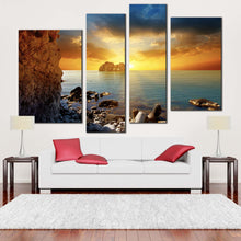 Load image into Gallery viewer, ocean rocks canvas wall art dramatic yellow cloudy sunset sky 4 piece multiple canvas blue sea ocean boulders canvas print in living room
