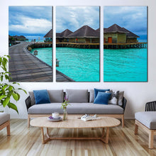 Load image into Gallery viewer, wooden bridge canvas wall art blue water villa 3 piece canvas set maldives hotel on water triptych canvas print In Living Room
